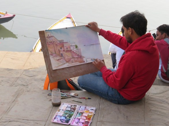 A man paints a water colour of the Ghats at Varanasi