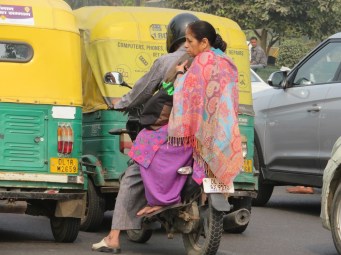 Lady on the back of a motor bike in Delhi