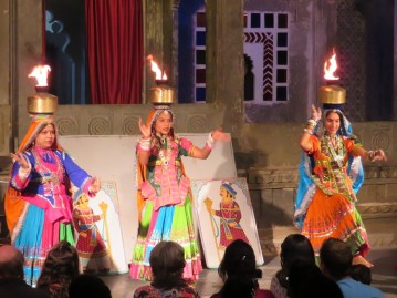 three ladies dancing with fire on their heads