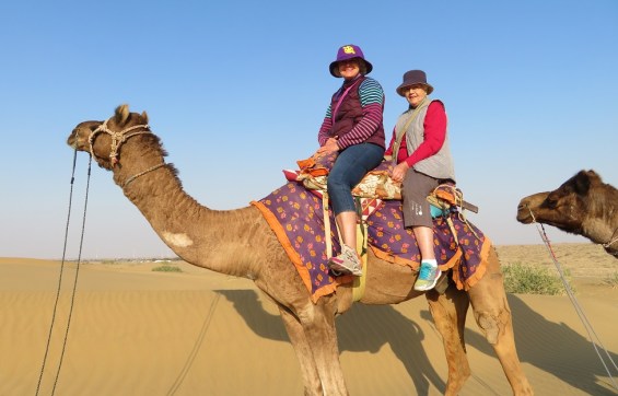 Two people ride a camel in the Thar Desert