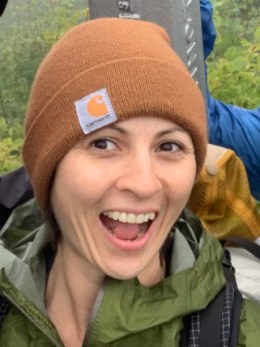 A smiling woman dressed in winter hiking clothes
