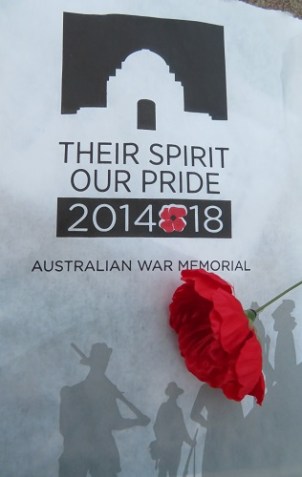 An image of the Australian War Memorial with a red poppy laying across the image