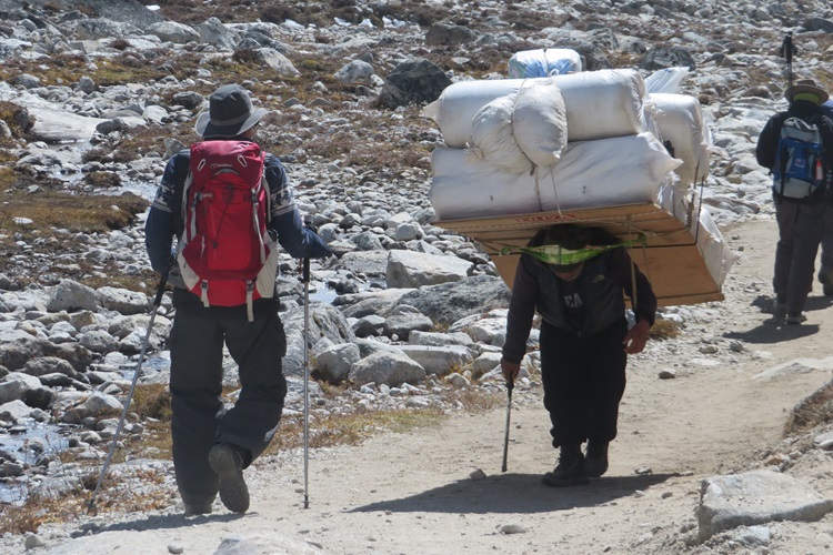 A porter carries a huge load on his back as he heads to Lobuche, Nepal